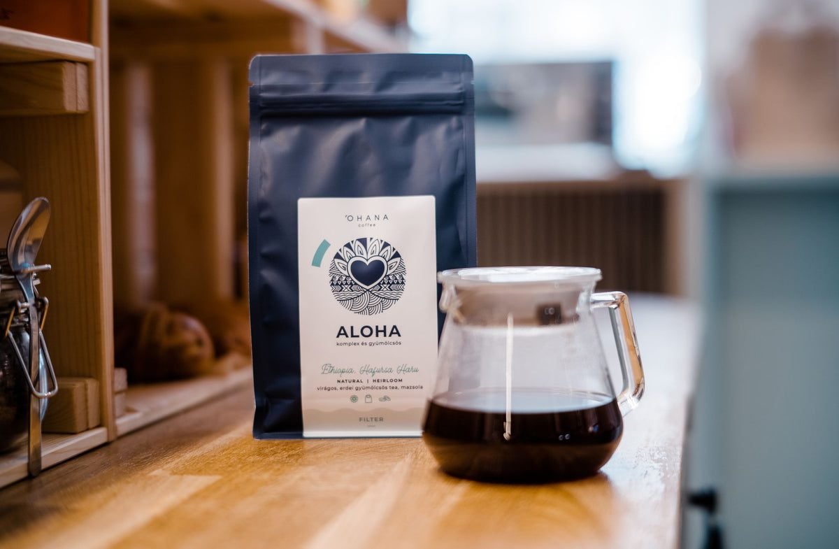 Aloha szemes kávé csomag és üveg filterkávé-kiöntő friss kávéval a pulton